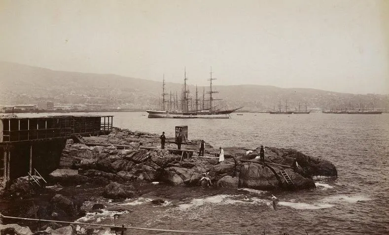 Bahía de Valparaíso con fragata de cuatro palos fondeada, vista desde los roqueríos — aprox. 1890–1930 | Chile de Ayer