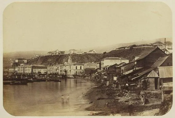 Valparaiso antiguo: orilla del mar con casas de madera y plan urbano al fondo — aprox. 1890–1930 | Chile de Ayer