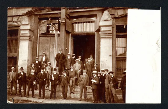 Grupo de hombres posando en escalinata de edificio dañado por el terremoto de 1906 — aprox. 1906 | Chile de Ayer