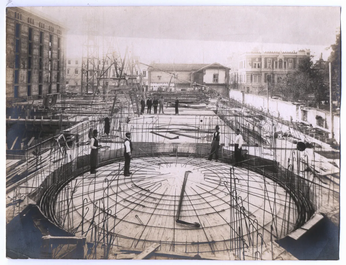Biblioteca Nacional en construcción, se divisa el cielo, techumbres y trabajadores — aprox. 1900 | Chile de Ayer
