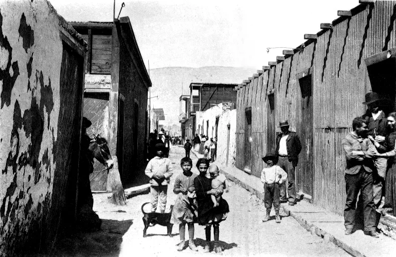 Niños y pobladores en calle principal del pueblo de La Noria, Tarapacá, hacia 1910 — 1910 | Chile de Ayer