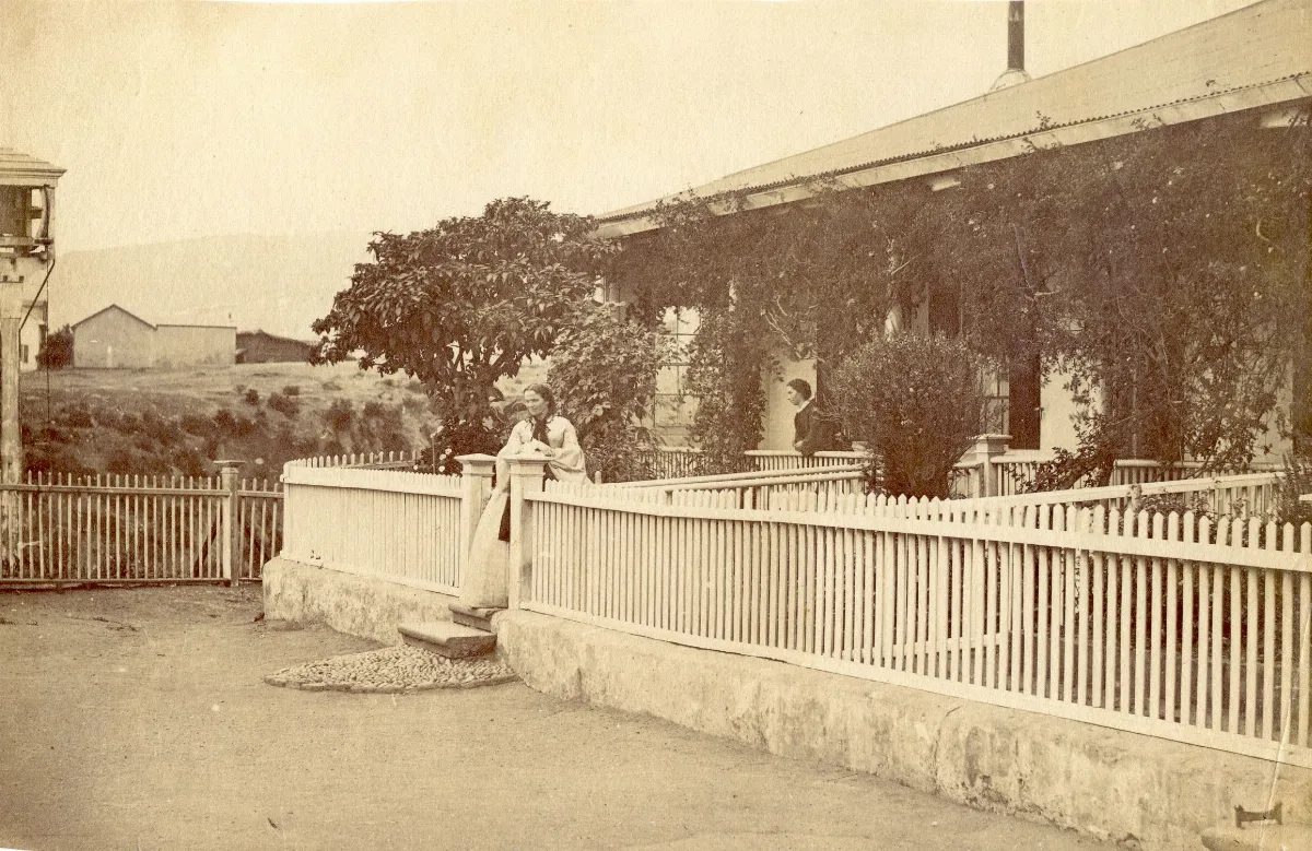 Porche de una casa del barrio de Cerro Alegre en Valparaíso con dos mujeres en la entrada de la casa. — 1863 | Chile de Ayer