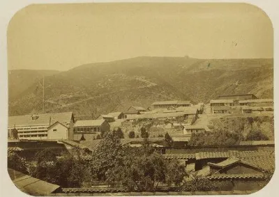 Panoramica sepia de un poblado chileno de cerro con casas de tejado y quebrada — aprox. 1890–1930 | Chile de Ayer