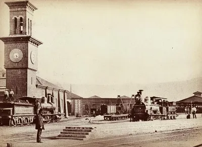 Estación ferroviaria con torre de reloj y locomotoras a vapor — aprox. 1890–1930 | Chile de Ayer