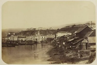 Valparaiso antiguo: orilla del mar con casas de madera y plan urbano al fondo — aprox. 1890–1930 | Chile de Ayer