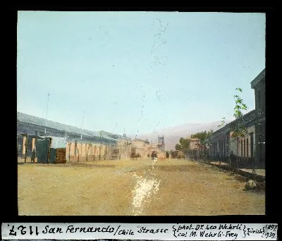 Calle principal de San Fernando con carretas y cordillera al fondo, diapositiva coloreada de 1897 — aprox. 1897–1940 | Chile de Ayer