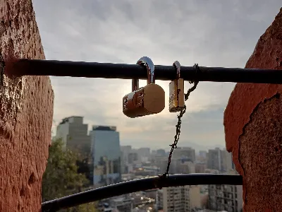 Candados de amor en la baranda del Cerro Santa Lucía con vista a Santiago — aprox. 1880–1930 | Chile de Ayer