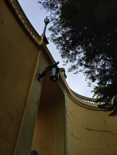 Muro curvo amarillo con farol de hierro en el Cerro Santa Lucía — aprox. 1880–1930 | Chile de Ayer