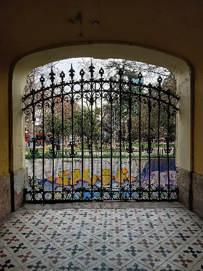 Puerta de acceso al Cerro Santa Lucía con vista a plaza arbolada — aprox. 1880–1930 | Chile de Ayer
