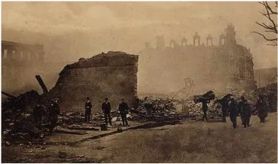 Hombres entre vigas y escombros al atardecer, silueta de iglesia al fondo, Valparaíso 1906 — aprox. 1906 | Chile de Ayer