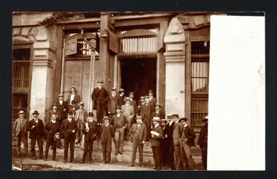 Grupo de hombres posando en escalinata de edificio dañado por el terremoto de 1906 — aprox. 1906 | Chile de Ayer