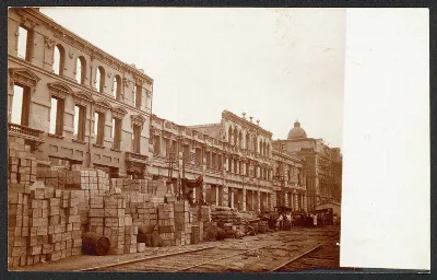 Calle de Valparaíso tras el terremoto de 1906: fardos y cajones apilados junto a edificios danados y rieles — aprox. 1906 | Chile de Ayer