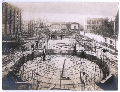 Biblioteca Nacional en construcción, se divisa el cielo, techumbres y trabajadores — aprox. 1900 | Chile de Ayer