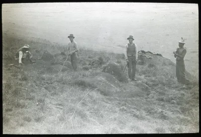 Four South American men standing around two excavated moai; Rano Raraku, Oc,G.T.1538, Mana Expedition to Easter Island, British Museum — Isla de Pascua — 1914 | Chile de Ayer