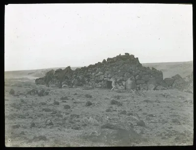 View of an ahu structure, made into a pyrramidal shaped house made from stones and with an entrance in the centre; a horse on the left, for scale; Hotu Iti(?), Oc,G.T.1622, Mana Expedition to Easter Island, British Museum — Isla de Pascua — 1914 | Chile de Ayer