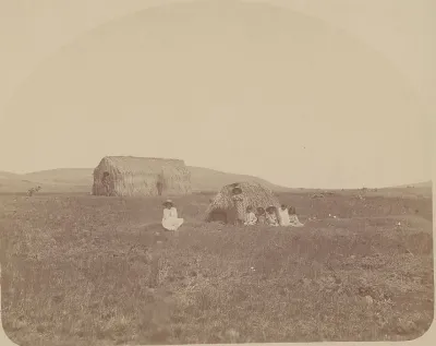 Group in Costume Outside Thatch House with Large Haystack In Background 1886 — Isla de Pascua — 1886 | Chile de Ayer