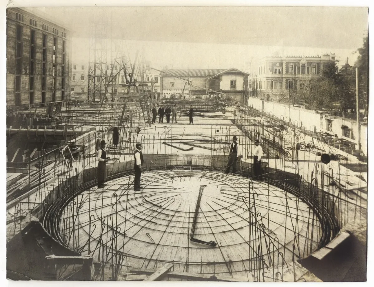 Biblioteca Nacional en construcción, se divisa el cielo, techumbres y trabajadores — aprox. 1900 | Chile de Ayer