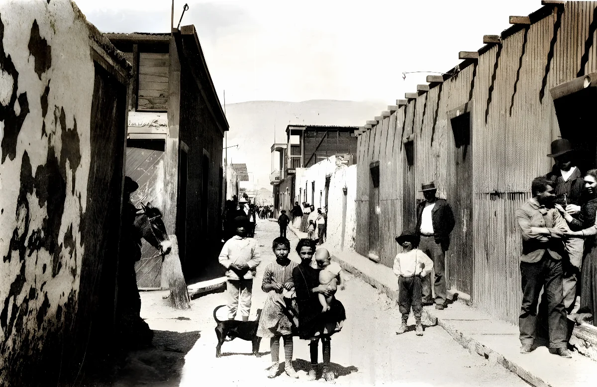 Niños y pobladores en calle principal del pueblo de La Noria, Tarapacá, hacia 1910 — 1910 | Chile de Ayer