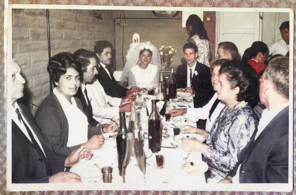 Novios e invitados centados en la mesa celebrando la fiesta de matrimonio — aprox. 1960 | Chile de Ayer