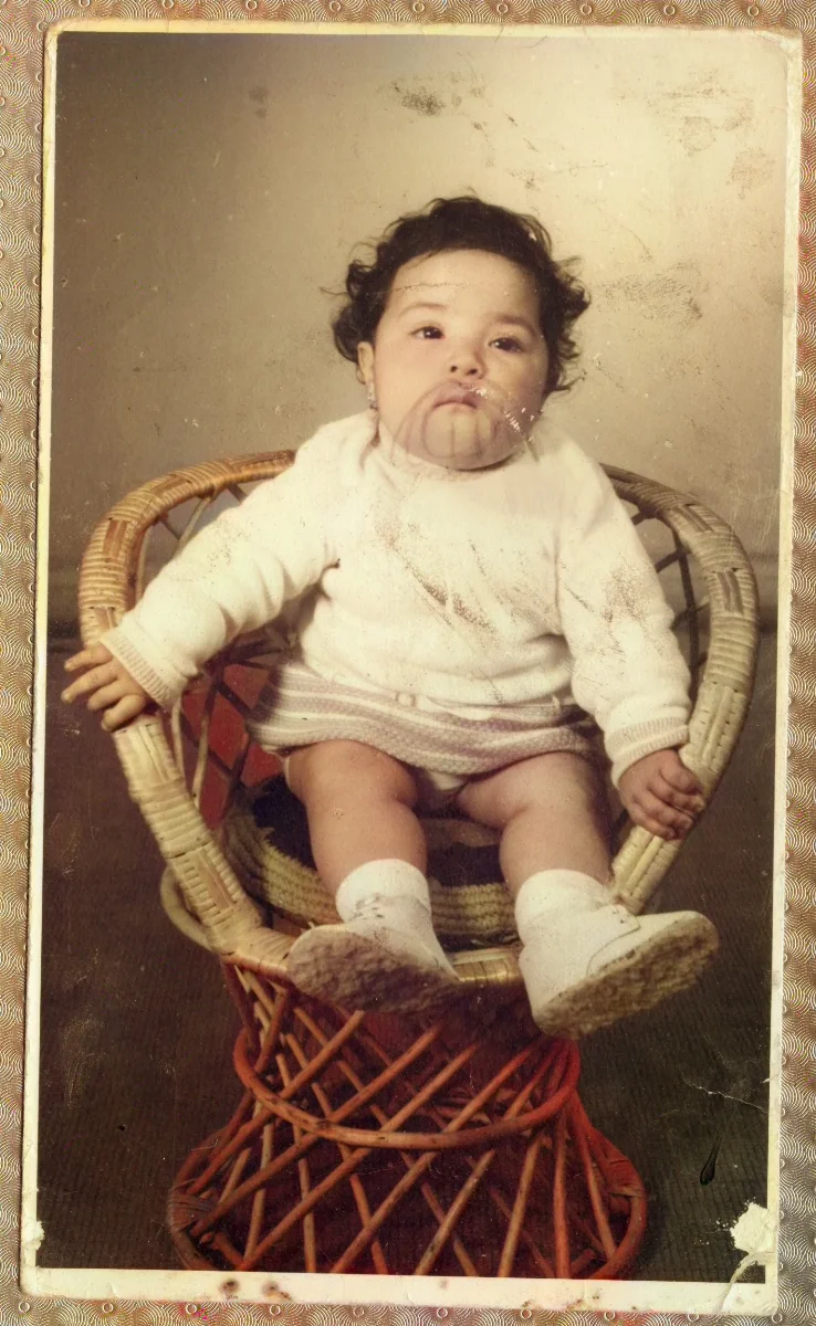 Bebé sentado en silla de mimbre — aprox. 1960 | Chile de Ayer