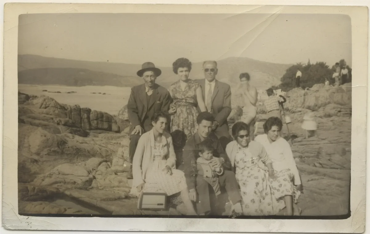 Paseo familiar a orilla de lago con grupo de nueve personas — 1960 | Chile de Ayer
