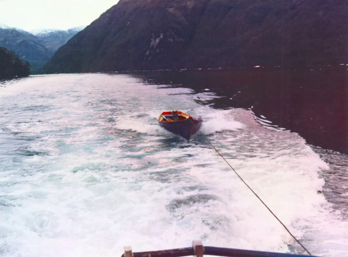 Viaje Tortel a Puerto Eden, remolcando bote desde Barcaza Orompello — Caleta Tortel — 1986 | Chile de Ayer
