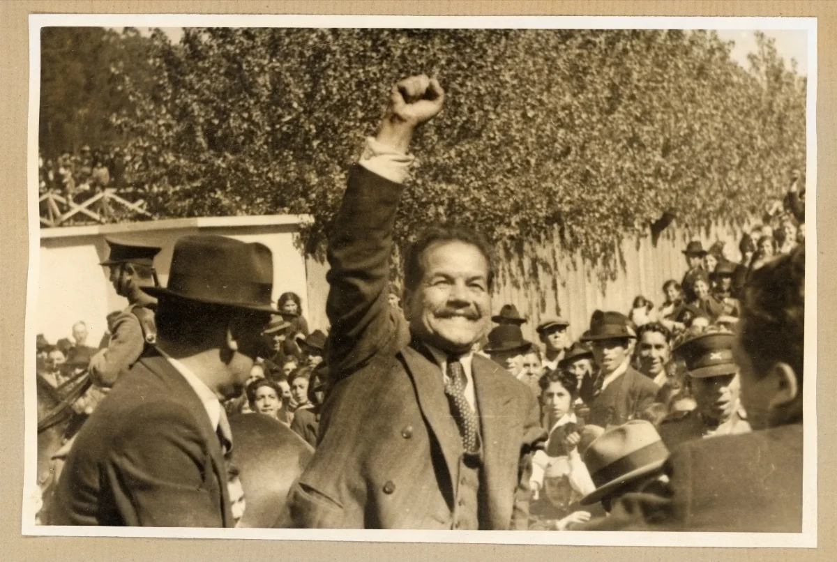 Presidente Pedro Aguirre Cerda con el puño en alto saludando a los habitantes que han venido a saludarlo — Puerto Varas — 1939 | Chile de Ayer