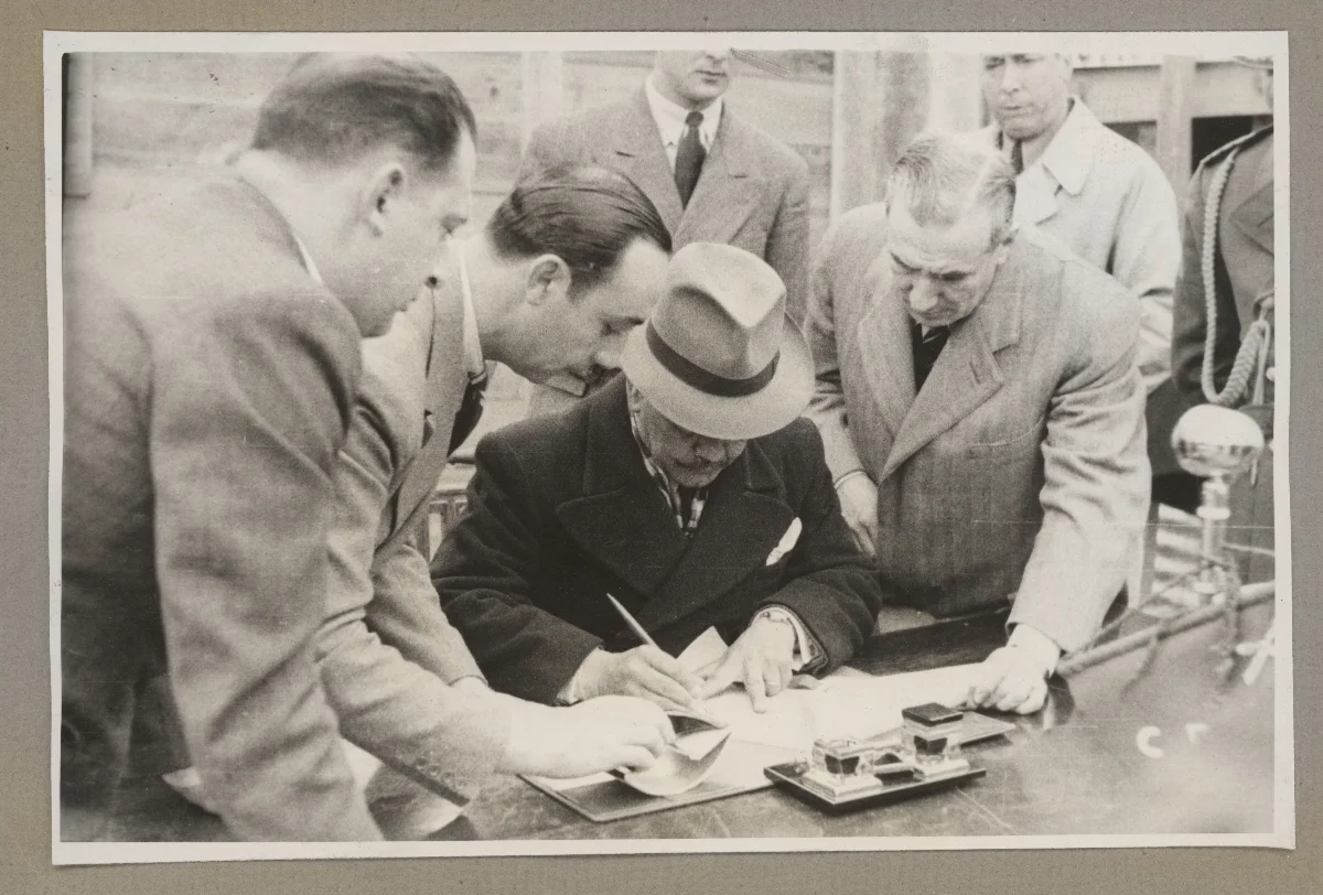 Presidente Aguirre Cerda inspecciona documentos rodeado de autoridades oficiales — aprox. 1939 | Chile de Ayer