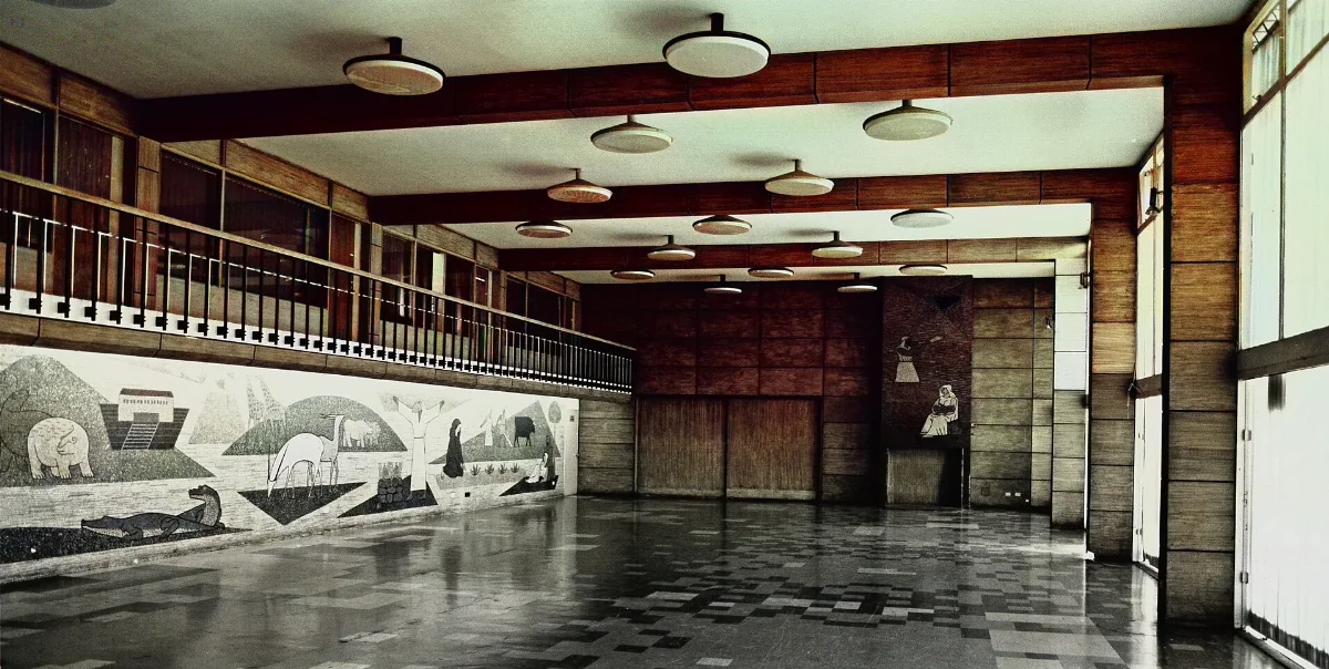 Hall modernista con galería y mural decorativo — aprox. 1955 | Chile de Ayer