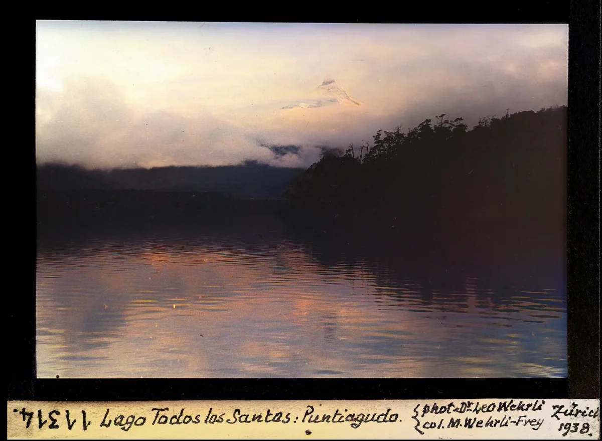 Volcán Puntiagudo entre nubes sobre el Lago Todos los Santos, diapositiva coloreada (1938) — aprox. 1938–1940 | Chile de Ayer