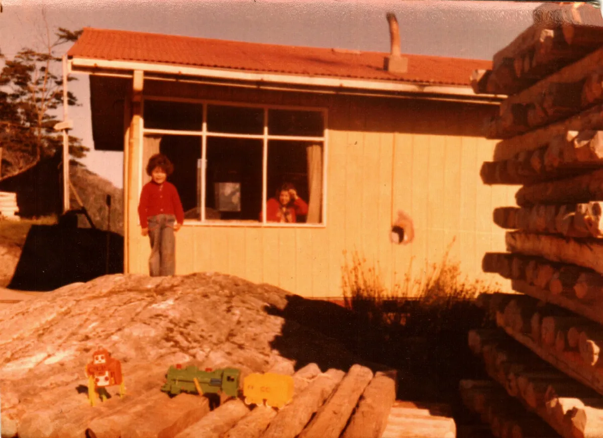 niño frente a casa funcionario ECA — Caleta Tortel — 1980 | Chile de Ayer