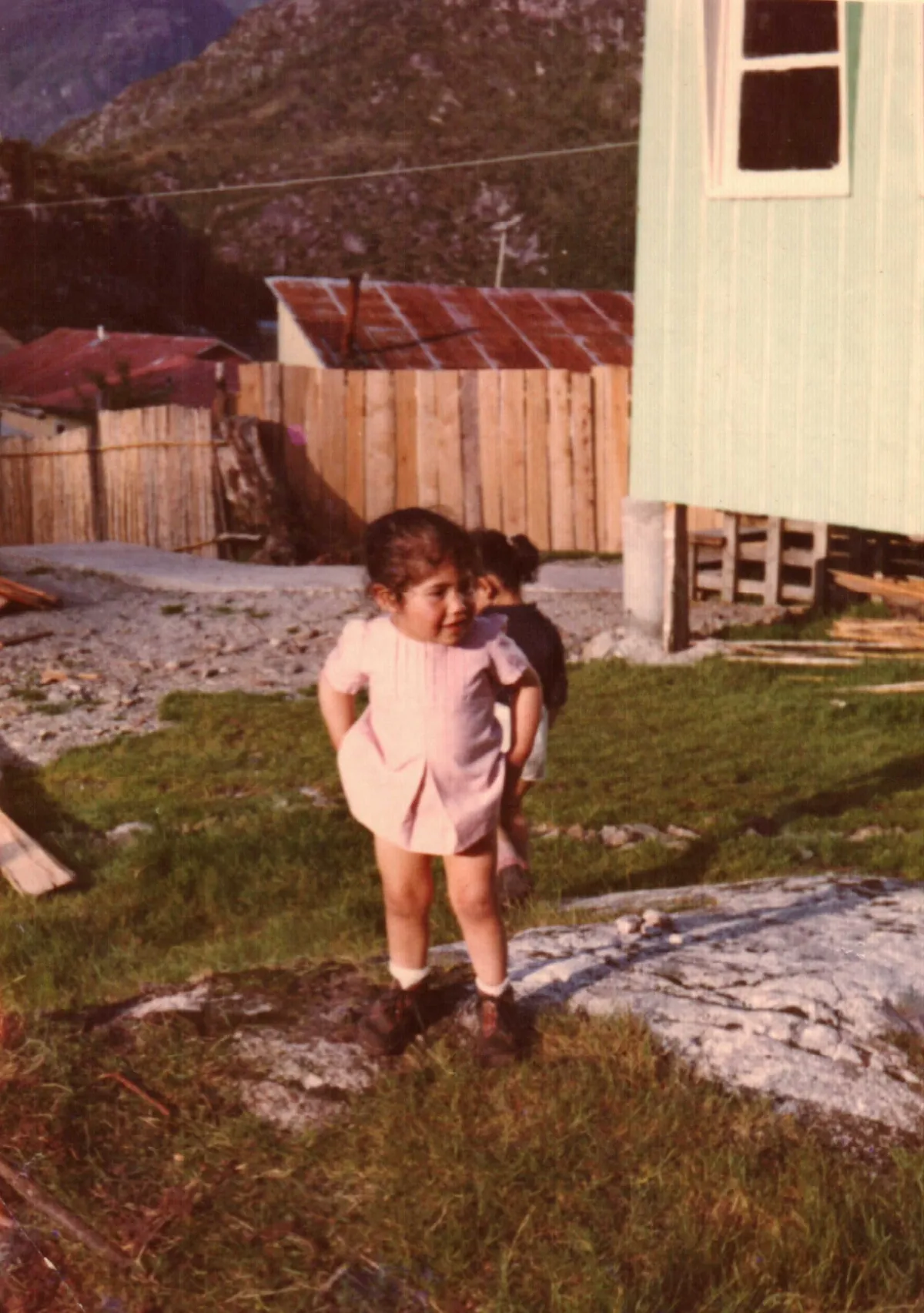Niña fuera de "Casa Verde", lugar donde se hicieron las primeras clases — Caleta Tortel — 1978 | Chile de Ayer