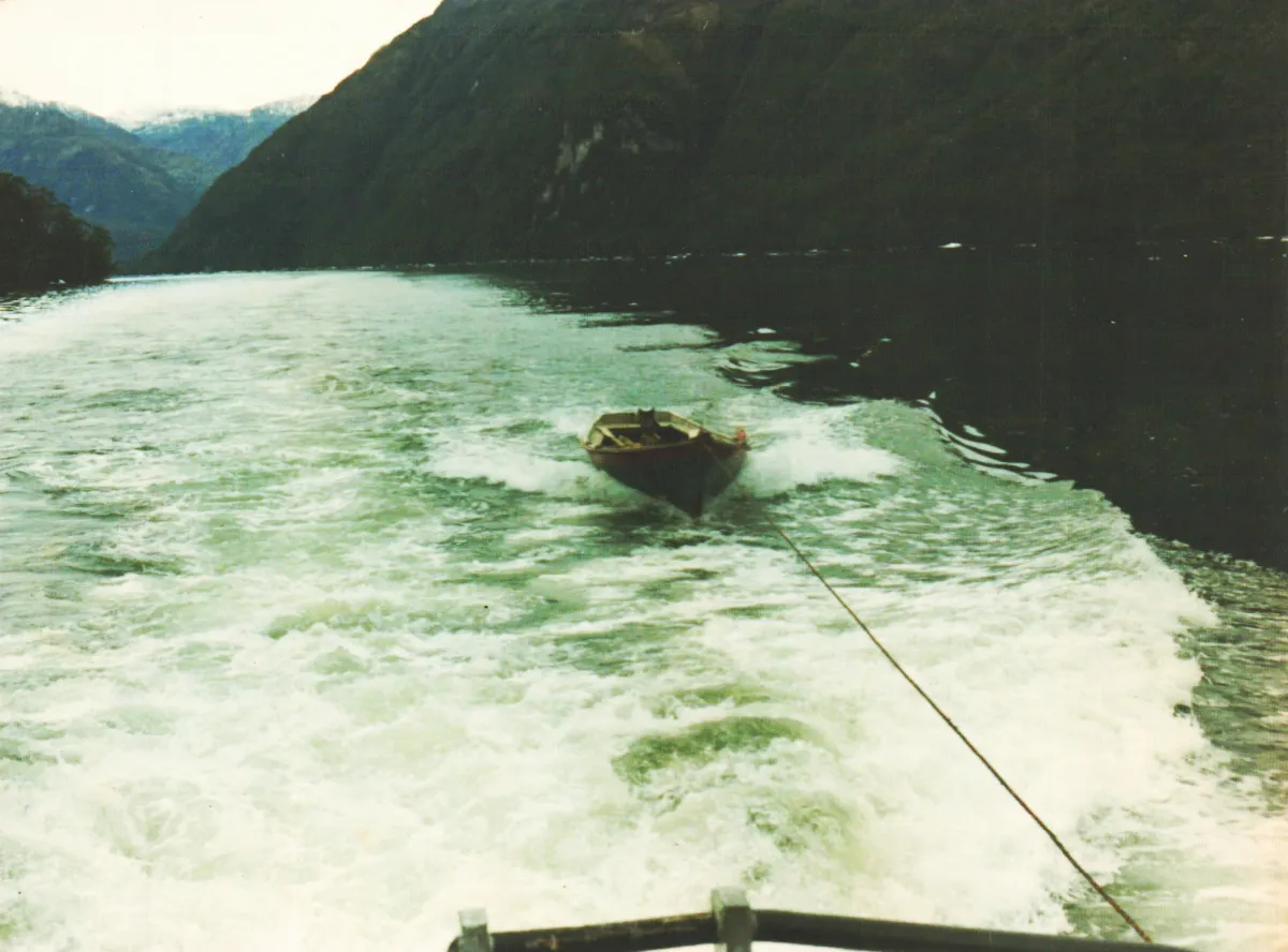 Viaje Tortel a Puerto Eden, remolcando bote desde Barcaza Orompello — Caleta Tortel — 1986 | Chile de Ayer