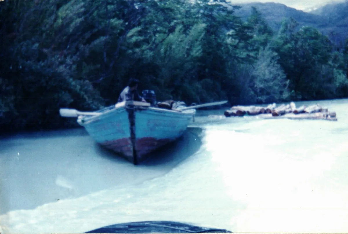 Bote siendo tirado por lancha. Balsa de madera — Caleta Tortel — aprox. 1996 | Chile de Ayer
