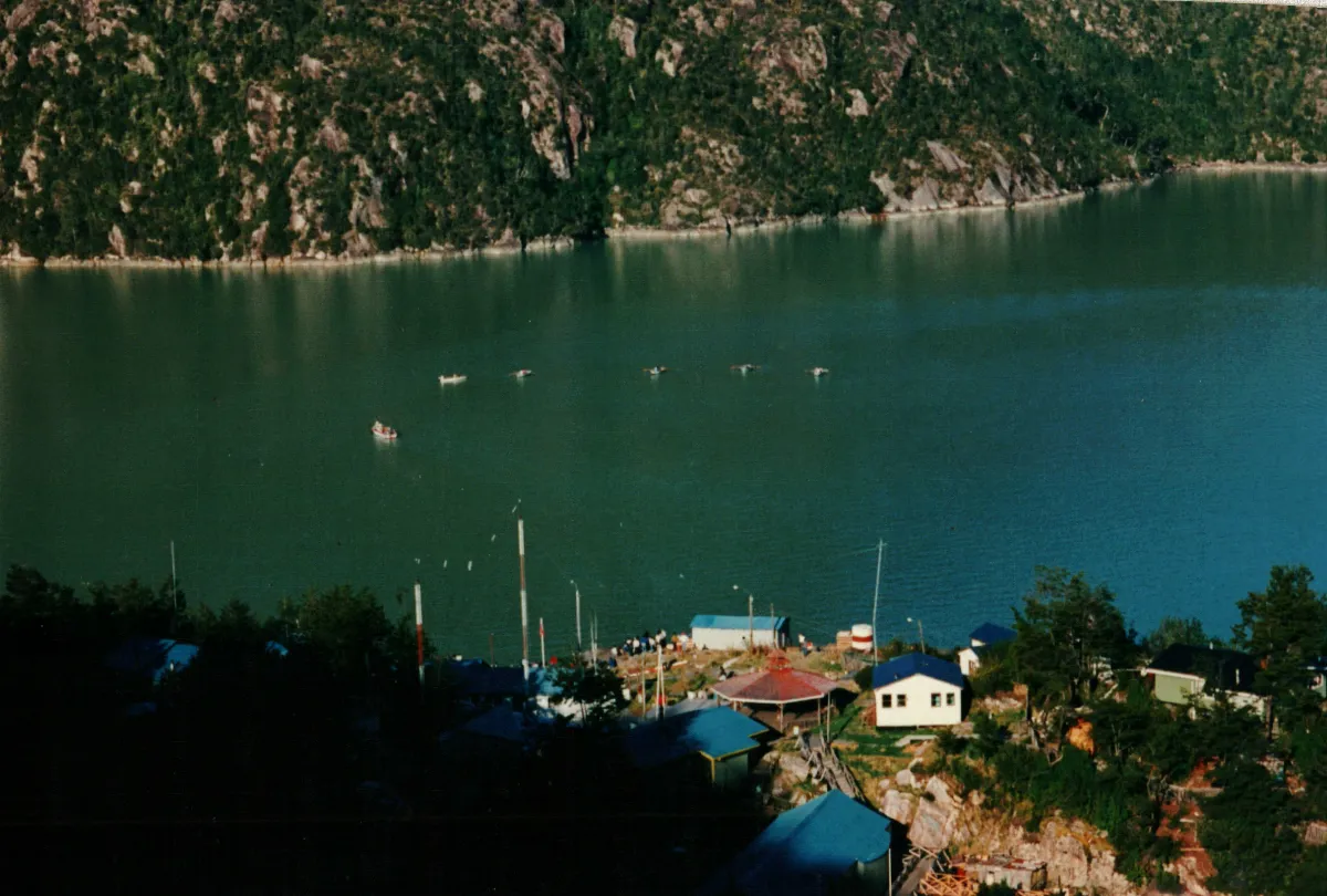foto panoramica, funeral en procesion en bote por bahia — Caleta Tortel — 1990 | Chile de Ayer