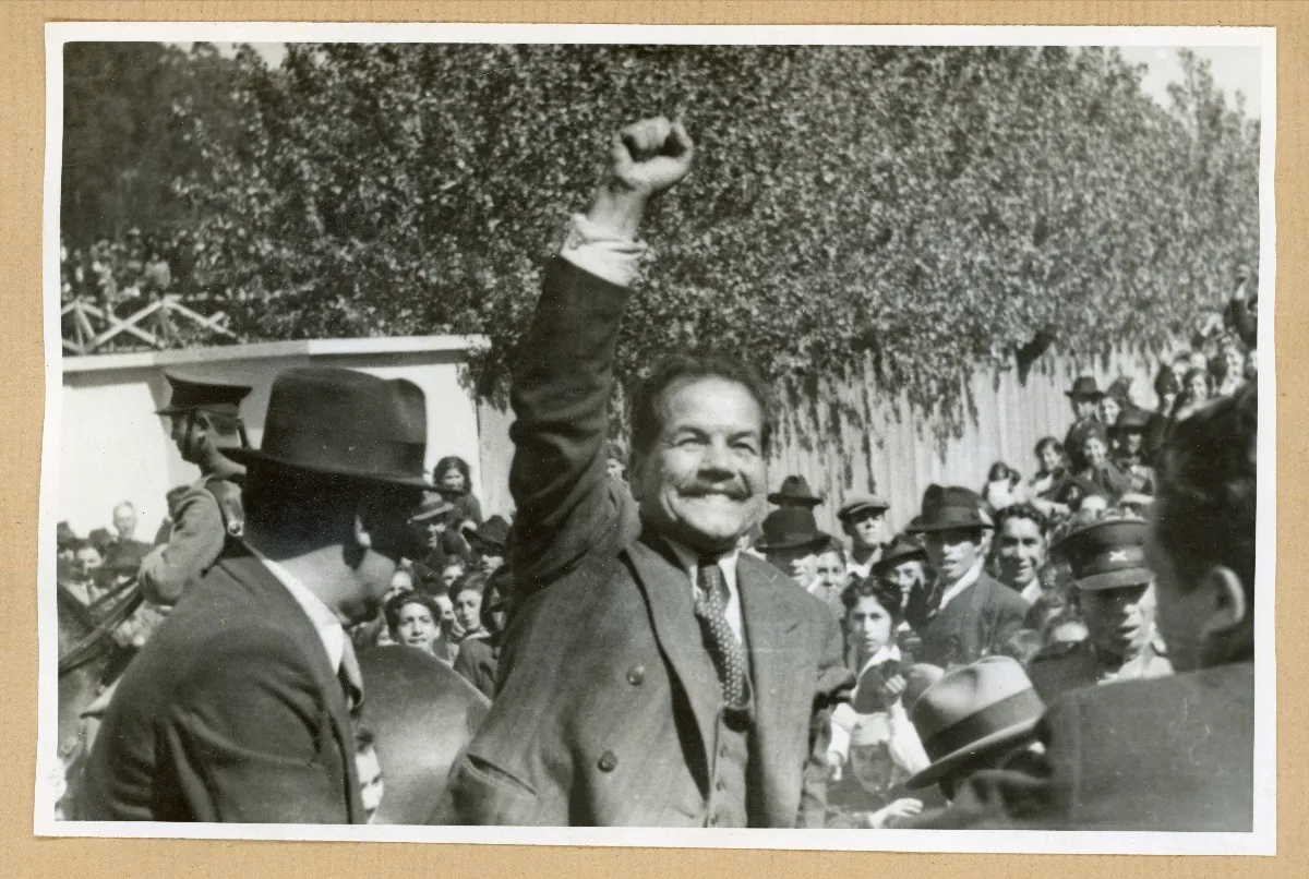 Presidente Pedro Aguirre Cerda con el puño en alto saludando a los habitantes que han venido a saludarlo — Puerto Varas — 1939 | Chile de Ayer