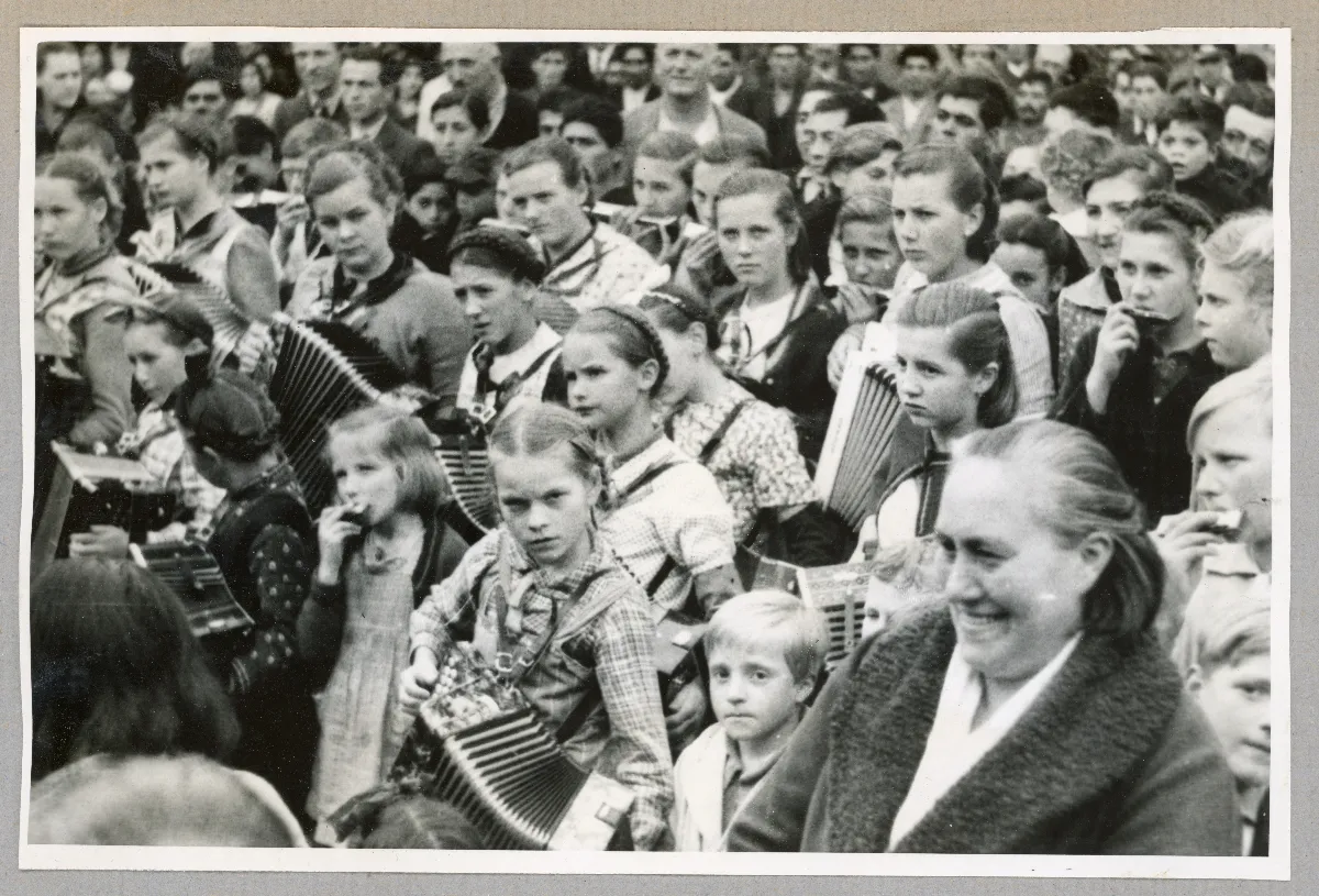 Multitud en acto cívico presidencial en Puerto Varas, con mujeres y niños portando banderas chilenas, 1939