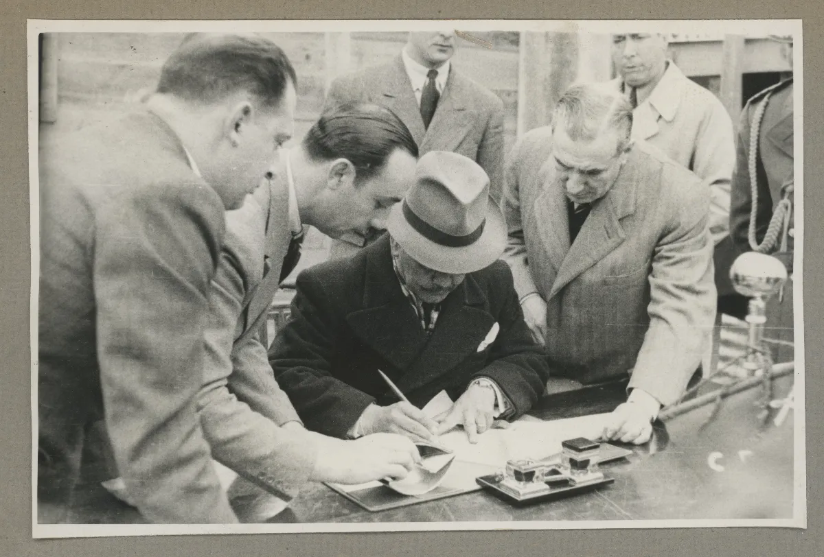 Presidente Aguirre Cerda inspecciona documentos rodeado de autoridades oficiales — aprox. 1939 | Chile de Ayer