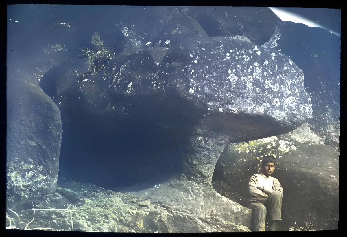 Chilean boy sitting underneath the sculpture, for scale; Rano Raraku, Oc,G.T.1644, Mana Expedition to Easter Island, British Museum — Isla de Pascua — 1914 | Chile de Ayer
