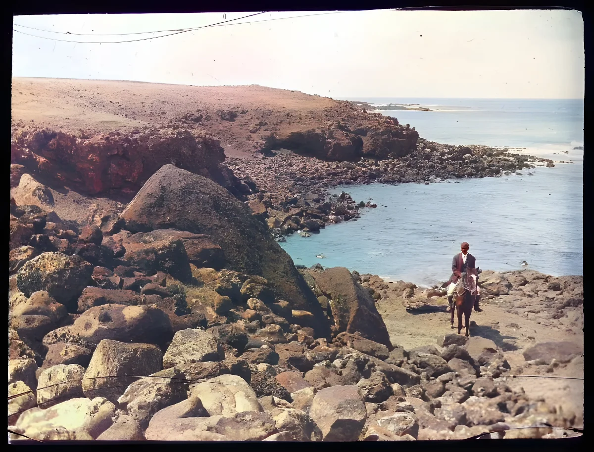 Landscape view, beside the coast, with a moai fallen on its back, towards the sea, and a man sitting on a horse for scale; Ahu Tetenga, Oc,G.T.1498, Mana Expedition to Easter Island, British Museum — Isla de Pascua — 1914 | Chile de Ayer