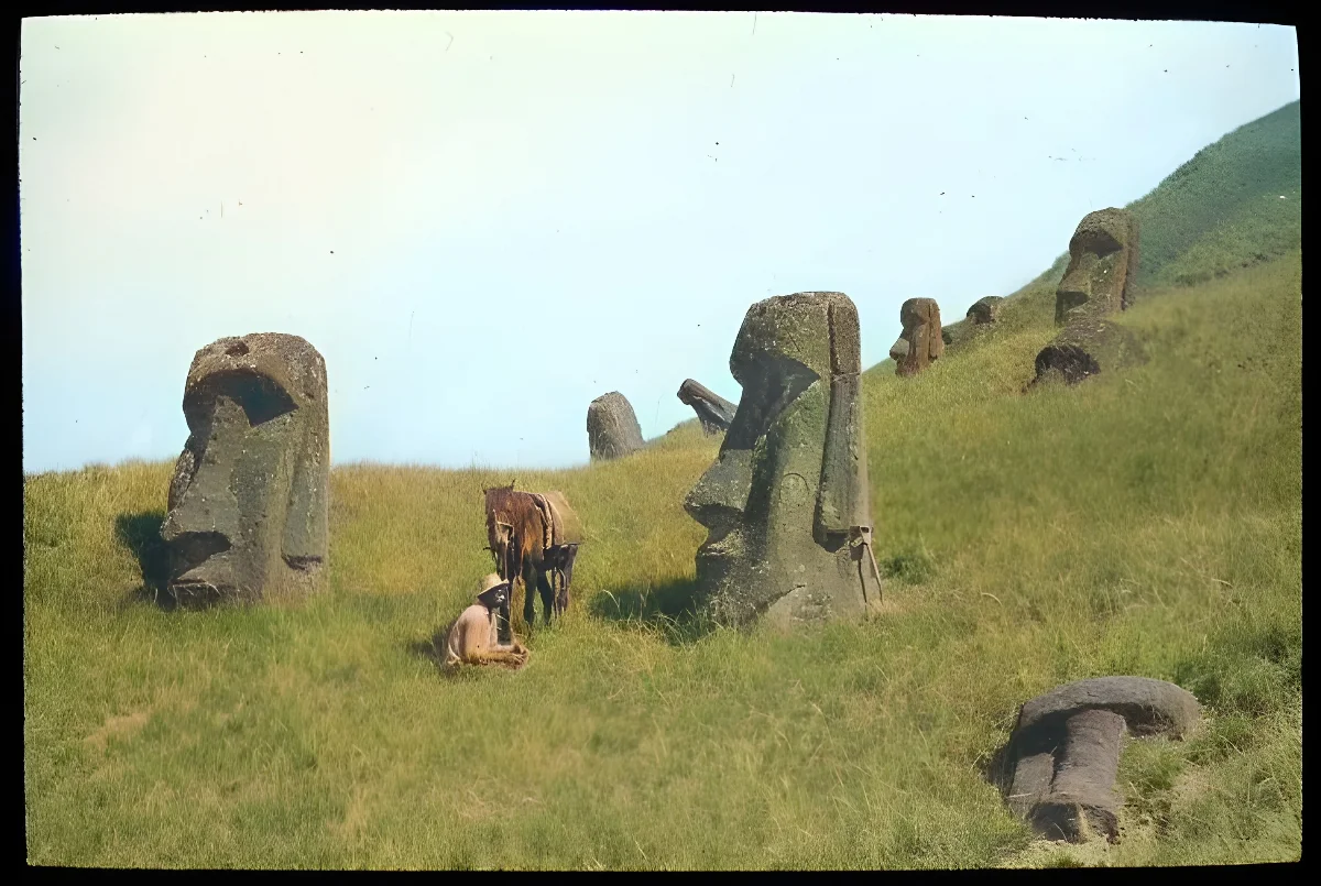 Polynesian(?) man sitting on the ground with a horse next to partially buried moai; Rano Raraku, Oc,G.T.1608, Mana Expedition to Easter Island, British Museum — Isla de Pascua — 1914 | Chile de Ayer