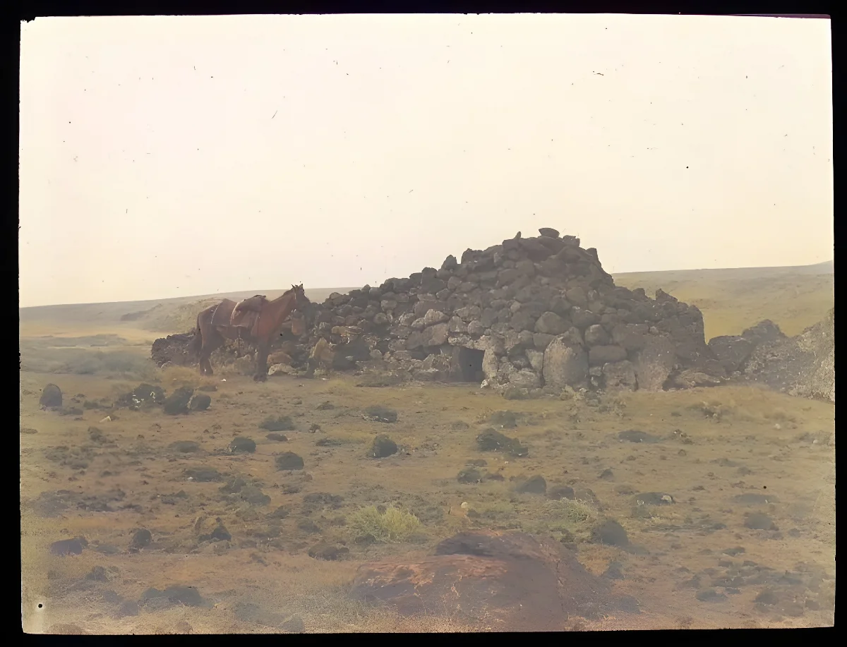 View of an ahu structure, made into a pyrramidal shaped house made from stones and with an entrance in the centre; a horse on the left, for scale; Hotu Iti(?), Oc,G.T.1622, Mana Expedition to Easter Island, British Museum — Isla de Pascua — 1914 | Chile de Ayer