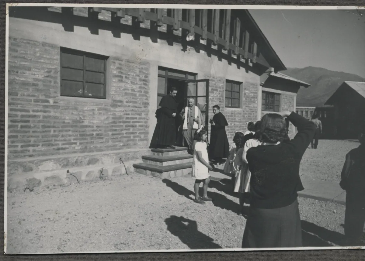 Mujer fotografiando a sacerdotes que visitan los "Colectivos" — Calle Larga — 1953 | Chile de Ayer