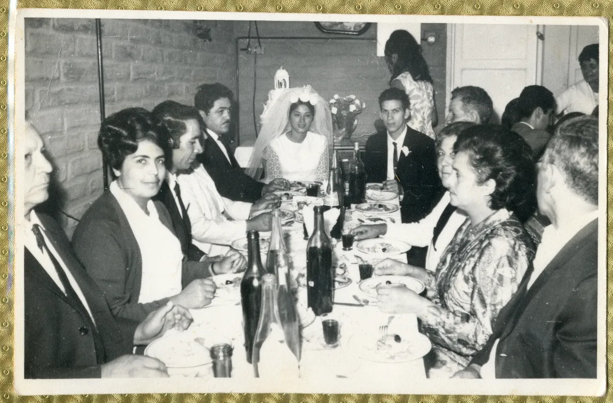 Novios e invitados centados en la mesa celebrando la fiesta de matrimonio — aprox. 1960 | Chile de Ayer