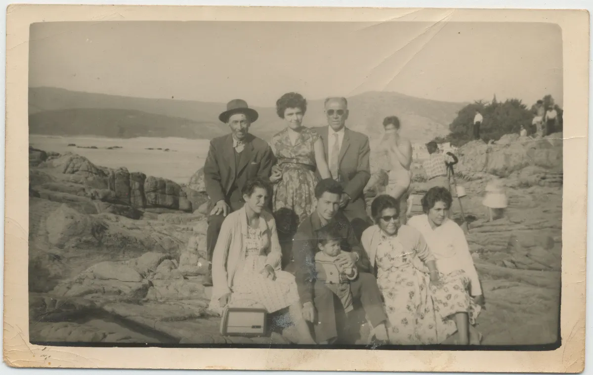 Paseo familiar a orilla de lago con grupo de nueve personas — 1960 | Chile de Ayer