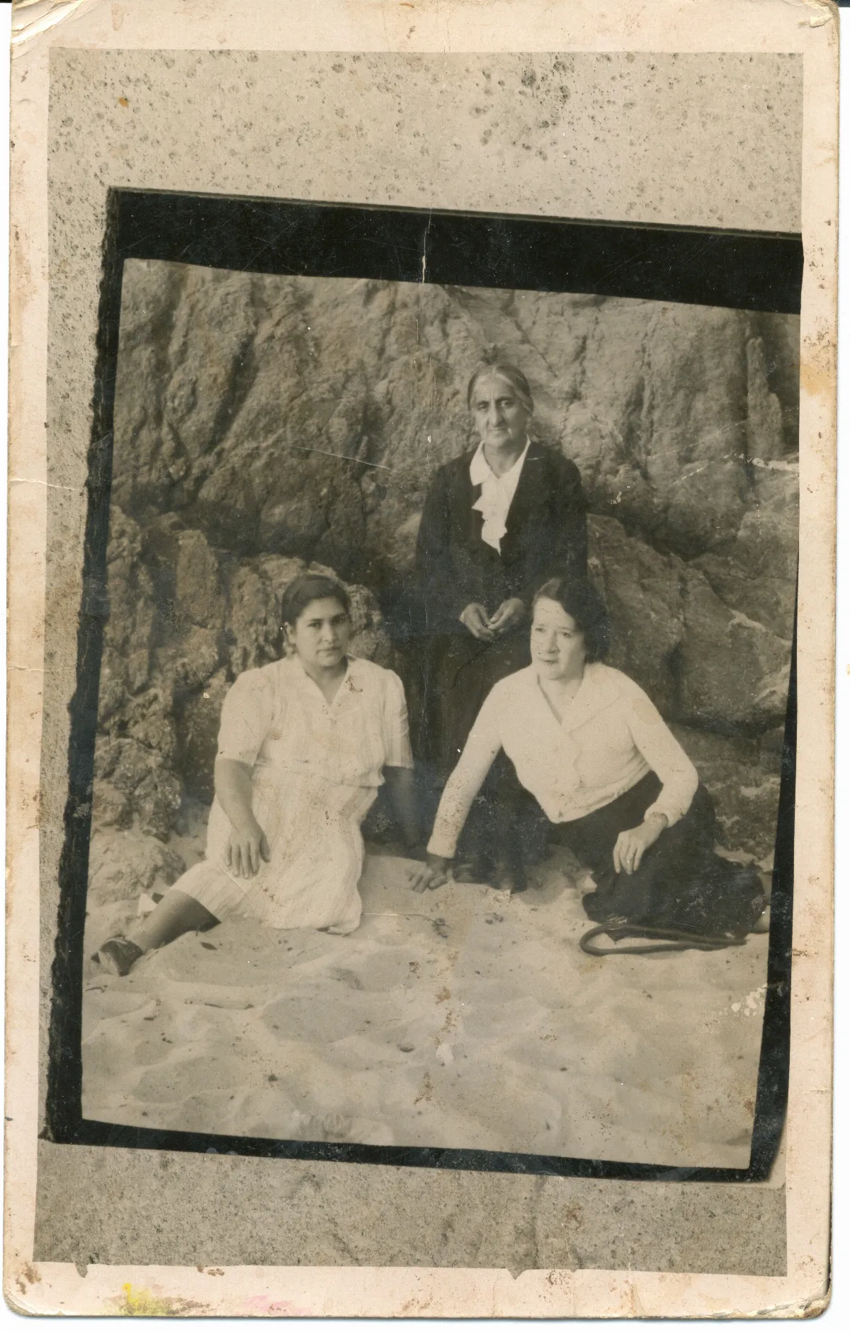 Tres mujeres en la playa con formaciones rocosas — 1920 | Chile de Ayer