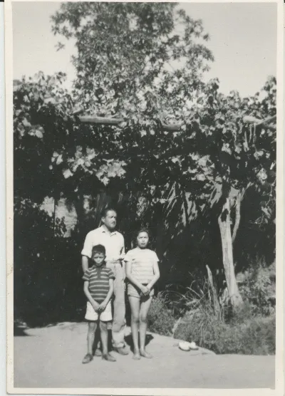 Padre junto a sus hijos bajo el parrón — Pocuro — 1966 | Chile de Ayer