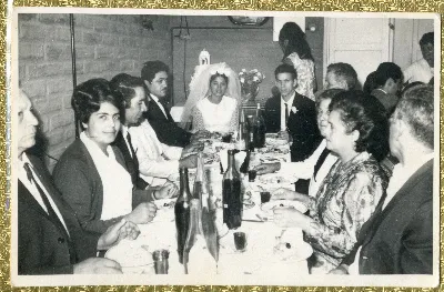 Novios e invitados centados en la mesa celebrando la fiesta de matrimonio — aprox. 1960 | Chile de Ayer