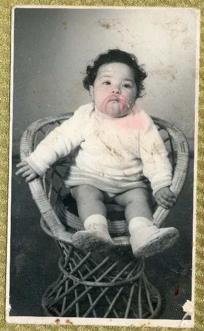 Bebé sentado en silla de mimbre — aprox. 1960 | Chile de Ayer