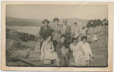Paseo familiar a orilla de lago con grupo de nueve personas — 1960 | Chile de Ayer